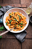 Vegan penne with lentil and carrot bolognese, wild garlic, sesame and yeast flakes