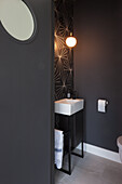 Dark guest bath with geometric wall pattern