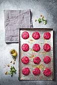 Uncooked red Beetroot burgers on metal tray