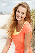 Junge blonde Frau in oragenfarbenem T-Shirt