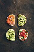 Variety of sandwiches for breakfast, snack, appetizers - avocado puree, mozzarella, tomatoes, basil, cream cheese, smoked salmon, red onion, cucumber whole grain bread sandwiches