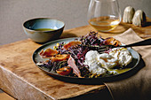 Salad with traditional italian burrata cheese, black arugula, grilled apricot, prosciutto, pistachio nuts and olive oil