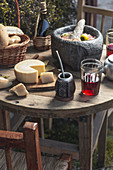 Salsa in Steinmörser, Yerba Mate, Rotwein und Käse auf rustikalem Holztisch