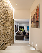 Brick wall and steps in hallway leading to masculine living room