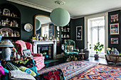 Eccentric living room with dark walls and colourful accessories