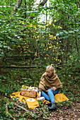 Young woman picnicking in a forest