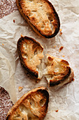 Slices of toasted baguette on parchment paper