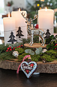 Rustic Advent arrangement with moss on slice of tree trunk