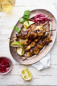 Marinated chicken skewers with pickled onions, tomato salad, lemon and yoghurt sauce