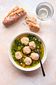 Chicken meatball soup with herbed broth in a bowl