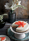 No bake cheesecake with pink grapefruit on a cake stand