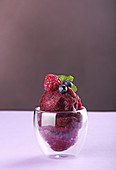 Berries sorbet in glasses (raspberry, blueberry) on violet color background