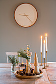 Schale mit natürlicher Weihnachtsdeko und Kerzen auf dem Tisch