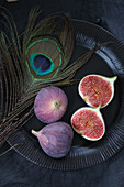 Fresh figs, whole and halved, on a black plate