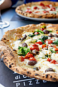 Pizza mit Tomaten, Oliven und Endivie