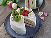 Creamy vegan matcha and raspberry cake with cream piping and decorated with mini Bundt cakes