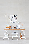 Home-Office in Weiß mit Schreibtisch auf Möbelböcken und Pinnwand