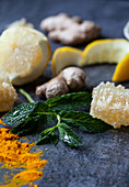 Lemon, ginger, turmeric powder, honeycomb and mint on a blue surface