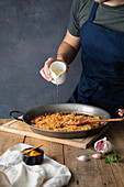 Paella mit Pflanzenöl beträufeln