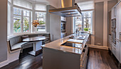 Long island counter and curved bench in bay window in elegant kitchen