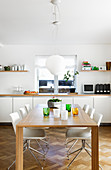 Dining table and modern chairs in front of long white sideboard