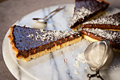 Chocolate tart with grated coconut, sliced