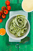 Fresh green tagliatelle with tomatoes, egg and flour