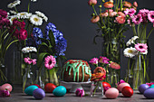 An Easter table laid with a Bundt cake, Easter eggs and flowers