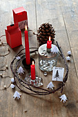 Festive arrangement with red candles in wreath of twigs