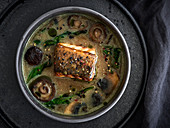 Soya milk soup with grilled salmon, mushrooms and vegetables
