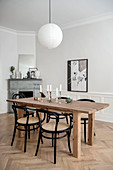 Black bistro chairs around dining table and open fireplace in period building