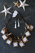 Handmade Advent calendar with numbered boxes made from brown paper threaded onto wreath