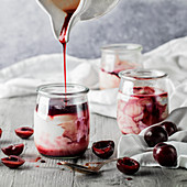 Yoghurt in pots with cherries and cherry sauce