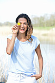 Junge Frau in hellblauem T-Shirt und weißen Shorts am Fluss