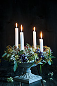 Advent wreath with hydrangea flowers and four candles in flower urn
