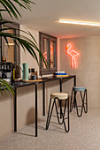 Narrow, black console table and stools below window