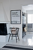 Stuhl mit Bastkorb unter Schriftbild im skandinavischen Haus