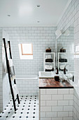 Ladder towel rack and bathtub in classic, attic bathroom with sloping wall