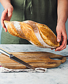 A baker holding a loaf of freshly baked bread