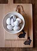 Easter eggs in bowl on wooden boards with Easter bunny motifs