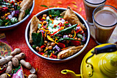 Chaat salad (spicy chickpea salad, India) with samosas and peanuts