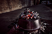 Cooking with cast iron pot on coal fire