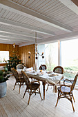 Set dining table and bamboo chairs in festively decorated interior