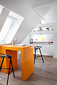 Orange, retro desk in open-plan attic apartment