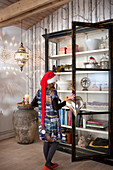 Child wearing Christmas hat in front of open display case
