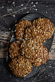 Oatmeal cookies on black plate and wooden background