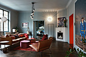 Leather sofa and easy chairs in living room in muted shades