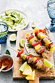 Easy chicken and pineapple skewers served with hot sauce and green salad