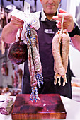 A butcher showing his wares, Catalonia, Spain