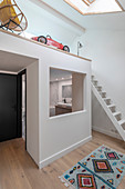 Ensuite bathroom below gallery in modern room with high ceiling